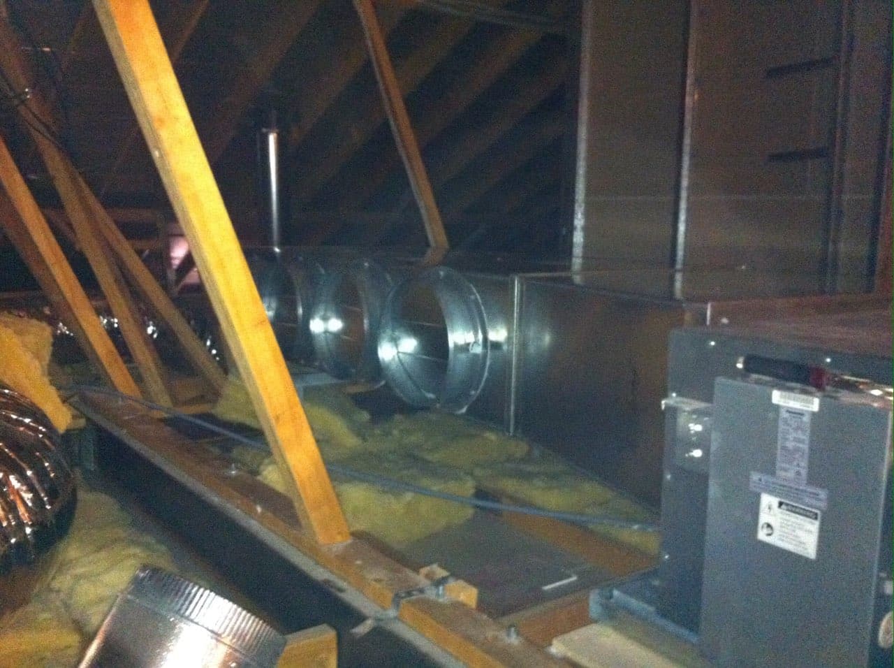 Ducted air conditioning plenum and take-off spigots beside the indoor fan coil unit in a roof space