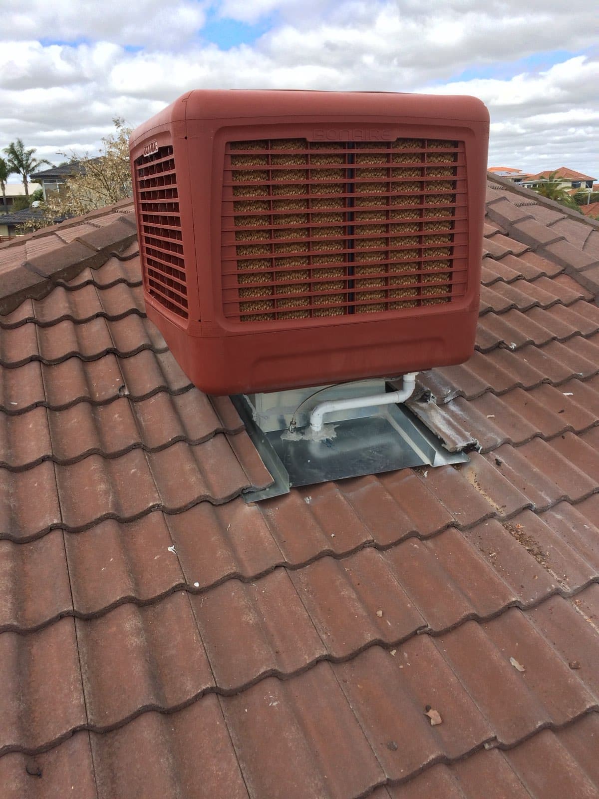 Bonaire evaporative cooler installed on a tiled roof, sealed to a galvanised roof penetration